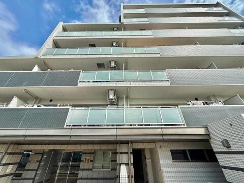 青空に映える端正なフォルム。街並みに調和するモダンなマンションです。
