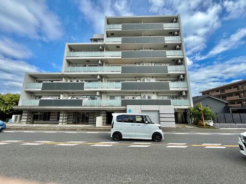 大きなバルコニーと開放的な外観が魅力。明るい街並みに映えるマンションです。