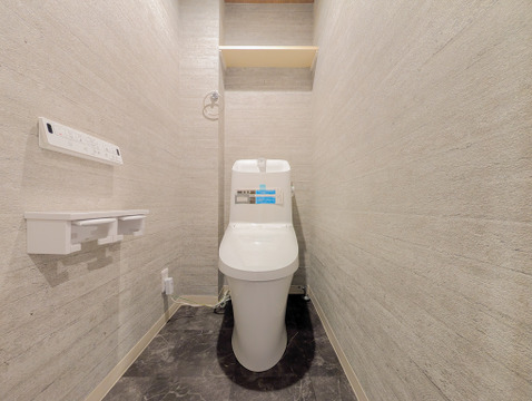 2連トイレットペーパーホルダーや上部棚を備えた、機能性とデザイン性の高いレストルームです。