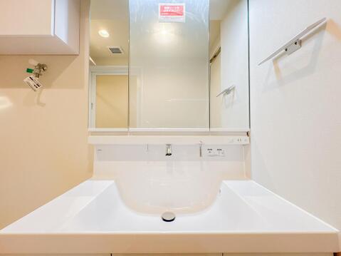 身支度がスムーズに行える三面鏡付きの洗面化粧台です。水栓周りに水が溜まりにくいお手入れのしやすい形状を採用しており、鏡の裏側には小物類を納められる収納を備えています。
