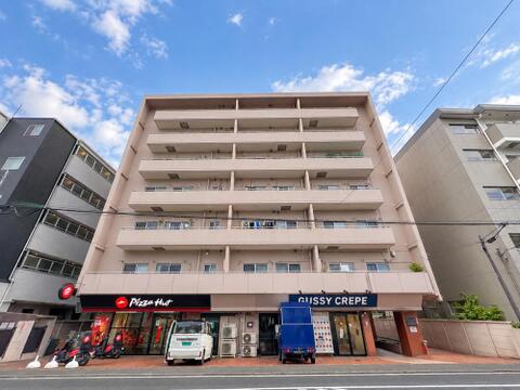青空に映える落ち着いたトーンの外観デザインが特徴的なマンション。1階店舗部分には飲食店などが入居しており、前面道路からのアプローチや移動もスムーズに行える立地です。