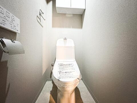 落ち着きあるデザインが印象的な清潔感あふれるレストルーム。便利な温水洗浄便座を完備し、上部にはトイレットペーパーなどを隠して収納できる便利な吊戸棚を備えた快適空間です。