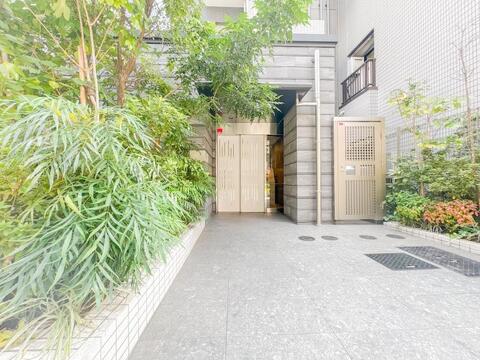 豊かな植栽の緑が住まい手を優しく迎えるエントランスアプローチ。石目調の意匠壁が施された高級感のある造りで、通りからのプライバシーにも配慮された安心の設計です。