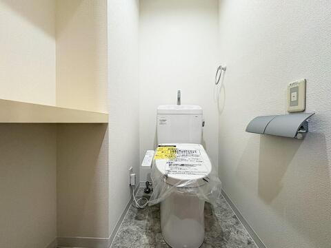 大理石調のフロアタイルが上品なレストルーム。温水洗浄便座や使い勝手の良いカウンター棚、2連ペーパーホルダー等を備えた、清潔感あふれる快適なプライベート空間です。