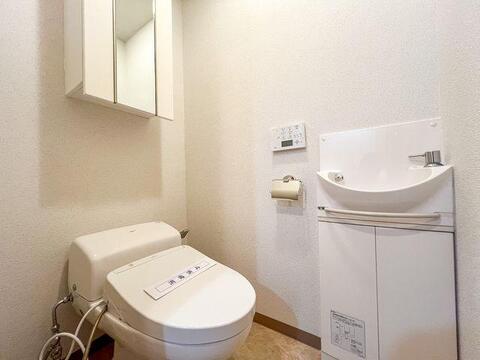 温水洗浄便座を採用。手洗いカウンターや日用品のストックに便利な吊戸棚を備えています。