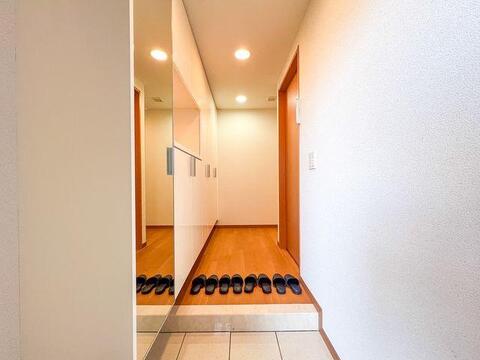 お出かけ前の身だしなみチェックに便利な大型姿見付き。明るくスッキリとした玄関空間です。