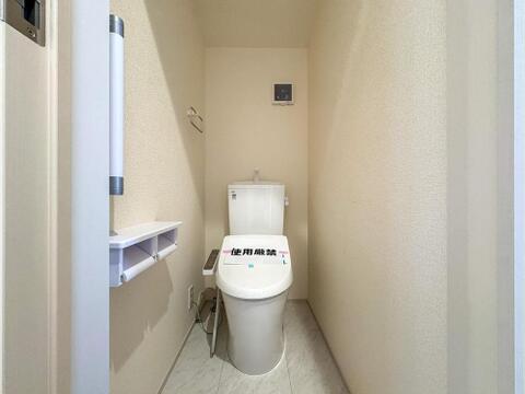 清潔感あふれるシンプルなトイレは、ウォシュレット機能付きで快適な使い心地です。トイレットペーパーホルダー付きの収納棚も備え、家族みんなが気持ちよく使える空間を演出します。