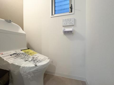 窓から光が差し込む明るいトイレ。清潔感あふれるホワイトで統一され、手洗い一体型で使い勝手も良好。