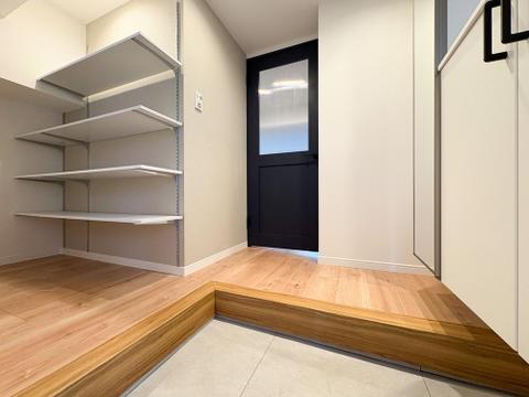 木の温もりを感じるフローリングと、シックな建具が調和。収納力の高い棚が、玄関周りを美しく保ちます。