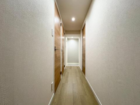木目調のドアが温かみを添える廊下。ダウンライトの光が、帰宅した家族を優しく迎え入れます。