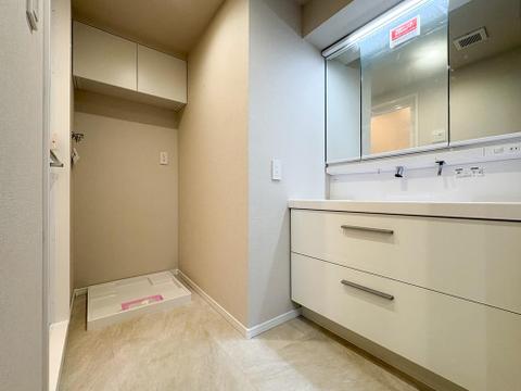 身支度がスムーズな三面鏡付き洗面台。洗濯機置場上部には棚があり、洗剤などをすっきり収納できます。