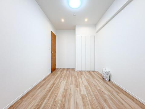 清潔感あふれる白壁と温もりあるフローリングが魅力の洋室。収納スペースも確保され、お子様のおもちゃや家族の荷物もすっきり片付き、広々と使えます。