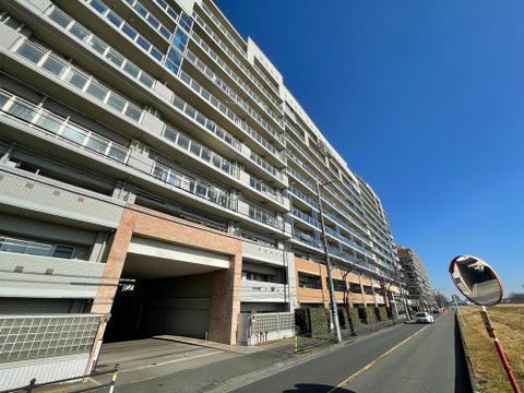 青空が広がる開放的な立地に佇む、大規模マンションの外観です。日当たり良好で、お子様が元気に育つ明るい環境。家族の笑顔が輝く毎日が始まります。