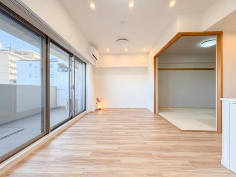 明るい陽光が差し込む広々としたリビング。隣接する和室は、お子様の遊び場や家族のくつろぎ空間に最適です。