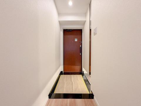 住戸のドアを開けると、明るい光が差し込む清潔感あふれる玄関がお出迎え。養生シートが新生活への期待感を高めます。家族の「いってきます」「ただいま」が心地よく響く空間です。