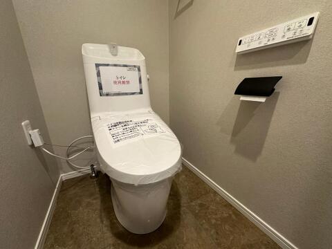 温水洗浄便座付きのトイレを新規交換。落ち着いたカラークロスとアクセント棚が調和し、毎日快適に使える空間に仕上がっています。