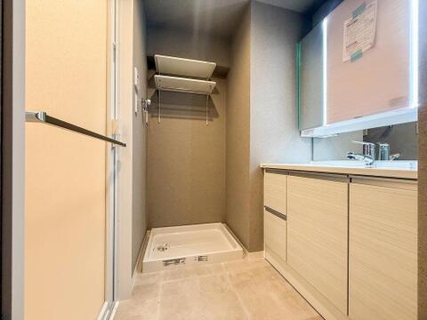 忙しい朝もスムーズに準備できる、機能的な洗面所です。洗濯機置き場には便利な棚があり、タオルや洗剤の収納に困りません。