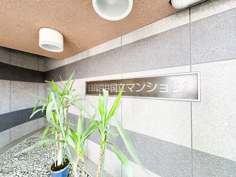 格調高い石貼りの壁面に、誇らしく掲げられた「日商岩井国立マンション」の館銘板。鮮やかな緑の植栽と柔らかな照明が彩りを添え、住まう人とゲストを優雅に出迎えます。物件の確かな品位を感じさせる入り口です。