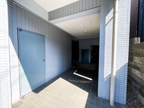 ブルーのタイル貼りが爽やかな、奥行きのある外観アプローチ。プライバシーに配慮された奥まった設計が、都会の喧騒を忘れさせる落ち着きを与えます。バリアフリーを意識したフラットな造りで、どなたでも安心して通
