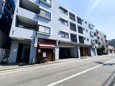 淡いブルーのタイル貼りが、青空に美しく映えるスタイリッシュな外観。規則的に並ぶ窓が洗練されたリズムを生み、都会的な風景に溶け込んでいます。街のランドマークとしての気品と清潔感を兼ね備えた佇まいです。