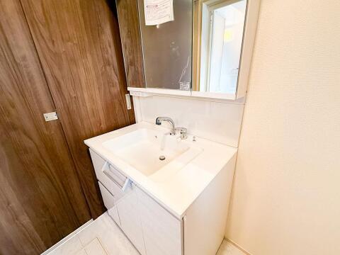三面鏡付きの広々とした洗面台は、朝の身支度もスムーズに。収納力も高く、家族みんなのアイテムをすっきり整理できます。