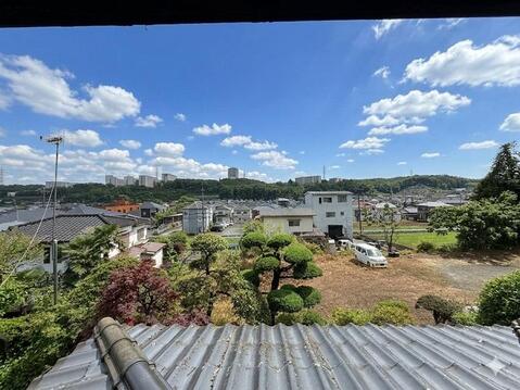 広い空と周囲の街並みを見渡せる眺望が広がり、敷地の広さと高台ならではの景色を楽しめます。庭木の緑も身近に感じられ、季節の移ろいを日常の中で感じられる住環境です。