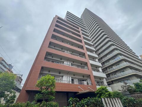 都会の空に映える、洗練されたデザインのマンション。広々としたバルコニーは、家族の笑顔と心地よい風を運び、日々の暮らしを豊かにします。