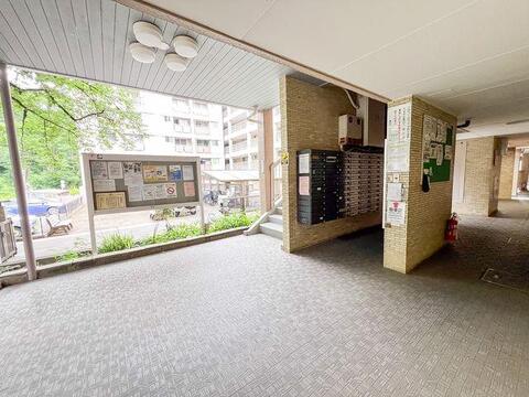大きな掲示板や集合ポストが整然と並ぶ、ゆとりあるエントランスです。