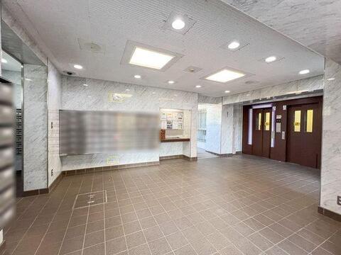 大理石調の壁面が明るく高級感のある雰囲気を演出するロビー。防犯カメラも設置されております。
