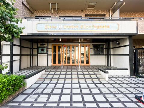 綺麗めなブランドサインと、重厚感あふれる石張り風の設えが風格を漂わせるマンションアプローチ。美しく整えられた植栽の緑と、温かみのある木目調のガラス扉が融合し、住まう方やゲストを華やかに出迎えます。