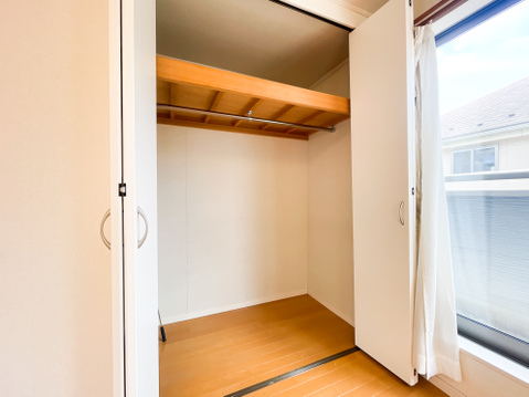 主寝室に完備された、開口が広く荷物の出し入れがスムーズな両開きの大型クローゼット。頑丈な木製の枕棚とハンガーパイプが標準装備されており、かさばるコート類や衣類をシワにせずたっぷり一括収納できます。