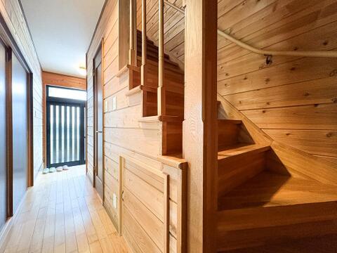 木の温もりに包まれたナチュラルな階段・ホール空間。手すり付きで安全面にも配慮されており、階段下のデッドスペースを活かした便利な収納も備わっています。