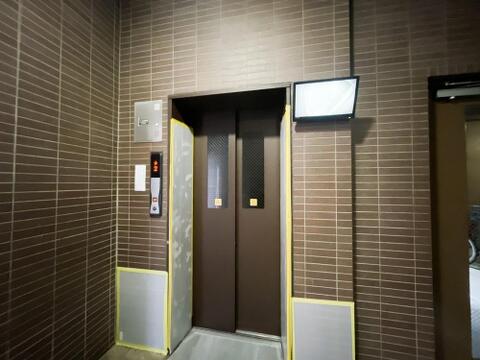 シックなブラウン調のデザインがロビーのタイル壁と美しく調和するエレベーター。乗り口の上部には防犯カメラのリアルタイム映像が映し出されるモニターを完備しており、夜間の利用も安心の高い安全性を誇ります。