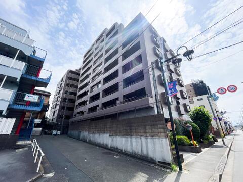 シックなブラウン調のタイル貼りが、青空の下で一際美しい存在感を放つ総戸数(階数)のある堂々たる外観。前面道路は歩道が整備され見通しが良く、周辺の穏やかな街並みとも調和あふれる佇まいです。