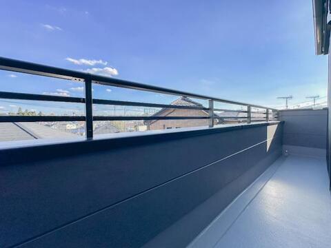 横方向に広がる手すりが印象的なバルコニー。周辺の住宅街や空を見渡せる開放的な眺めが広がります。腰壁と手すりを組み合わせたつくりで、洗濯物を干す場所としても活用できる屋外スペースです。