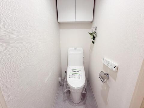 清潔感あふれる最新式のトイレは、温水洗浄機能付きで快適。上部収納で空間もすっきり、家族みんなが気持ちよく使えます。