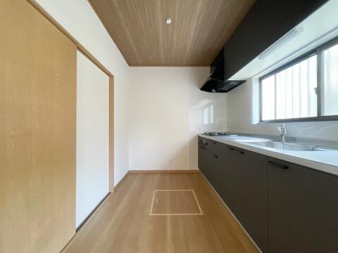 シックなダークカラーが映えるシステムキッチン。便利な床下収納・窓付きで換気もスムーズ。