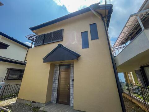 温かみのあるアースカラーの外観。スタイリッシュな屋根デザインと小窓がおしゃれな戸建てレジデンス。
