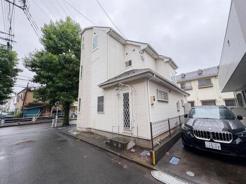 白い外壁が清潔感を演出する、ゆとりのある邸宅。駐車スペース完備で、家族のお出かけもスムーズです。