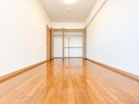 壁一面に大容量の折れ戸式クローゼットを配した洋室。衣類から大きな生活用品までまとめてすっきり収納できるため、居住スペースを広く使って落ち着いたインテリアコーディネートが可能です。
