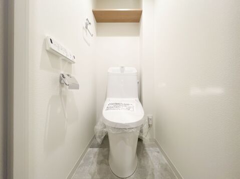快適な温水洗浄便座付きトイレ。上部には便利な棚板付きで、トイレットペーパーのストックもスッキリ。