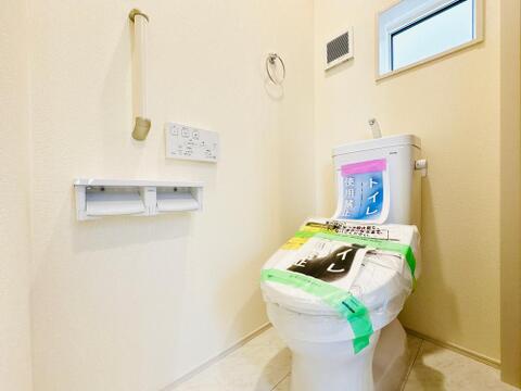 手すりや小窓を備えた安心・清潔なトイレ。温水洗浄機能付きで快適な日常をサポートします。