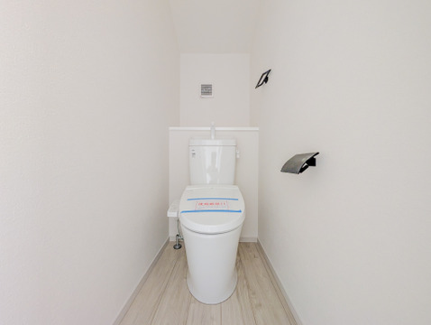 白を基調とした空間に、黒のペーパーホルダーとタオル掛けを合わせたスタイリッシュなトイレです。