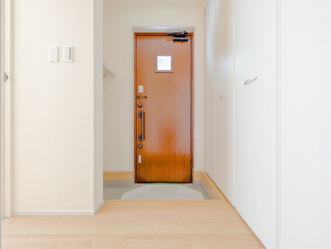 落ち着いたブラウンの玄関ドアと明るいホワイトの壁面が調和する、上品な玄関です。