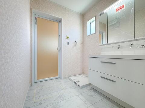 石目調フロアの洗面室。小窓からの自然換気と便利な床下収納を備えた快適空間。