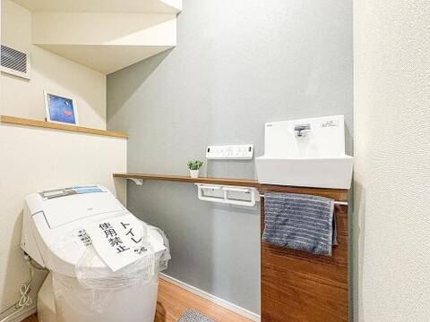 アクセントクロスがおしゃれなレストルーム。便利な独立手洗い器に加え、小物を飾れるカウンターや棚を備えた、インテリアも楽しめるこだわり空間です