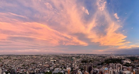 夕日に照らされて染まるドラマチックな雲と街の風景。