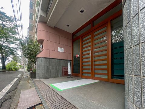 木の温もりあふれる大扉が印象的なアプローチ。フラットな足元で車椅子やベビーカーも安心です。