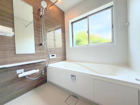 木目パネルが癒やしを醸し出すバスルーム。小窓付きで換気もしやすく、毎日の疲れを心地よく癒やします。