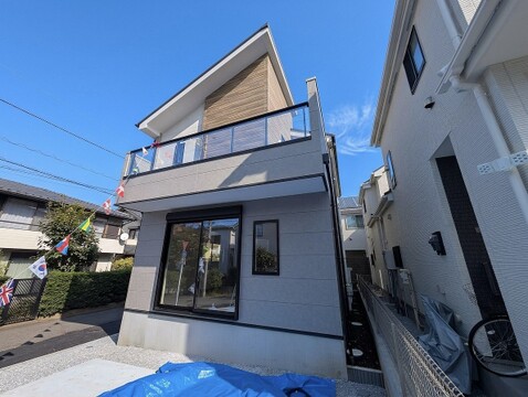 大胆な斜めの屋根ラインに沿って配された木目調サイディングが、建物のをスタイリッシュに演出しています。